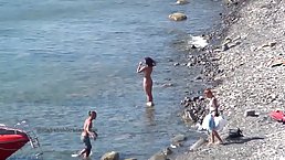 Sexy girls expose tanned bodies at the nudist beach