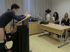 A guy giving speech while a blonde professor is giving him a blowjob in front of the commity