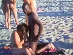 Horny couple is having sex on the beach while their friends are watching them in action