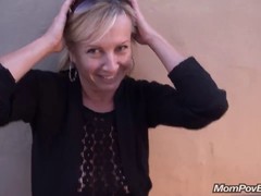Mature blonde is sucking dick in a public toilet and playing with her tits at the same time