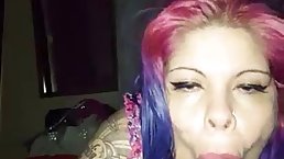 An amateur, ebony girl with pink and purple hair is sucking dicks like a slut
