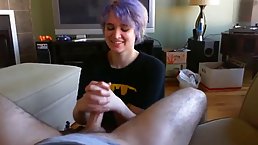 Emo chick with purple hair is gently rubbing her partner's dick and getting ready to suck it