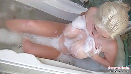 Big titted blonde is playing with her milk jugs while taking a relaxing bath at night