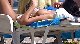 Sweet, topless girl is enjoying on the beach while guys are staring at her tits