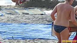 Topless ladies are enjoying on the beach even while guys are staring at their tits