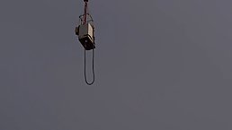 Naked babe is about to do her first bungee jump, while many people are watching her