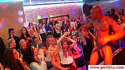 Horny woman is sucking a black man’s huge cock, while other people are watching, at the party