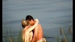Amateur couple is making love on the beach, while a bad voyeur is recording a video