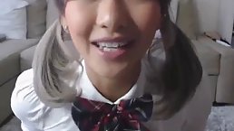 Lovely Asian schoolgirl is playing with her rubber sex toy, while in front of the camera