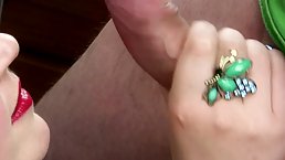 Experienced woman with red lips is gently licking her lover's balls and sucking his cock