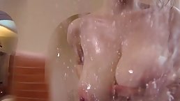 Voluptuous brunette with massive tits, Karina Hart is making an erotic video in the bathroom
