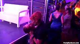 Dark haired woman is kneeling in front of her horny guy and sucking his cock, during a party