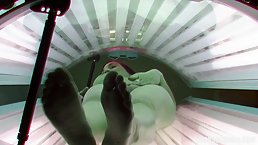 Sweet brunette is naked in the tanning room not knowing about a hidden camera there