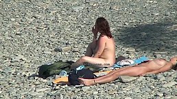 Nude women are enjoying on the beach while a kinky man is taking photos of them