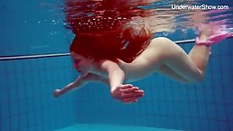 Simonna is a sweet, red haired babe who shows her naked body in the swimming pool