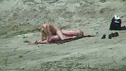 Naked blonde is fucking aman on the beach, not knowing that someone is watching them