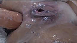 Slutty brunette milf is thoroughly oiled up and ready to drill her ass with a dildo
