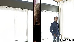 Experienced woman in a sexy, black dress is pleasing a handsome man in the bathroom
