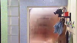 Hot brunette with firm, round tits, June is having a shower in front of the camera