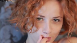 Seductive redhead is slowly taking off her clothes and touching herself before fingering her pussy