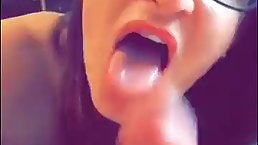 Amateur brunette with big, black glasses is sucking her lover's cock in front of the camera