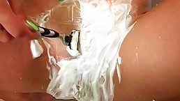Short haired brunette is masturbating in the shower after shaving her pussy and enjoying it a lot