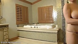 Mature blonde with big boobs is masturbating with a huge sex toy in the bathroom