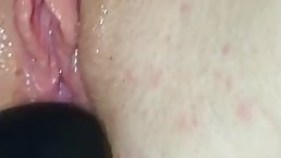 Horny girl is getting a black dildo inside her soaking wet pussy, in front of the camera