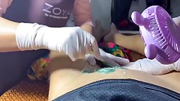 Two experienced ladies are giving a Brazillian waxing treatment to a guy with a huge dick