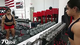 Muscled brunette is lifting weights in front of the camera, because it excites her a lot