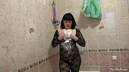 Hot brunette in erotic clothes is masturbating with a shower and moaning from pleasure while cumming