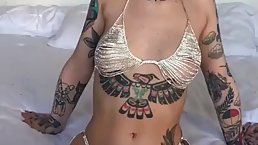 Tattooed teen brunette with long, red nails is masturbating in front of the camera and enjoying it