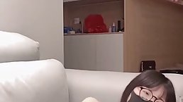 Small titted Asian girl is wearing a mask and glasses while spreading up on live cam