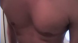 Passionate brunette is giving blowjobs to two handsome guys while kneeling in front of them