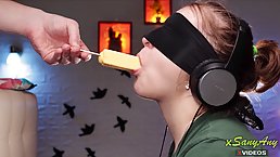 Blindfolded babe is eagerly sucking a rock hard dick while listening to her favorite music