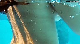 Small titted brunette, Candy is enjoying in the swimming pool naked, because she likes the feeling