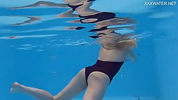 Lovely girl is often wearing tiny bikinis and very slowly getting naked while swimming alone