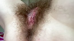 Charming milf is gently fingering her hairy pussy in front of the camera, just for fun