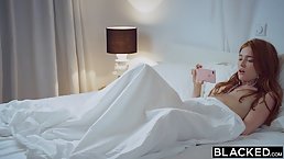 Lovely redhead is moaning while having sex with a tattooed, black guy, in his apartment