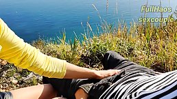 Russian babe is giving a handjob to a horny man in the nature, during the day