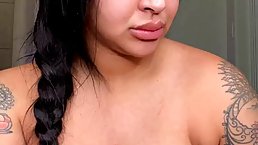 Ebony babe with tattoos and big boobs is displaying her pierced nipples in front of the camera