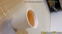 Japanese teen is peeing in a plastic cup because she likes how it feels and sounds
