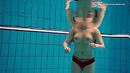 Busty redhead babe Vesta swims naked