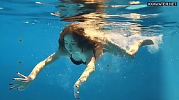 Young redhead babe swimming topless in the pool